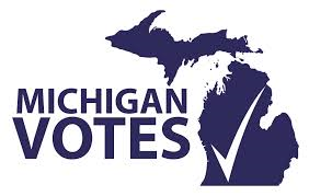 A graphic with the state of Michigan on the right, a check mark is inside the state of Michigan shape. On the left is text that reads "Michigan Votes"